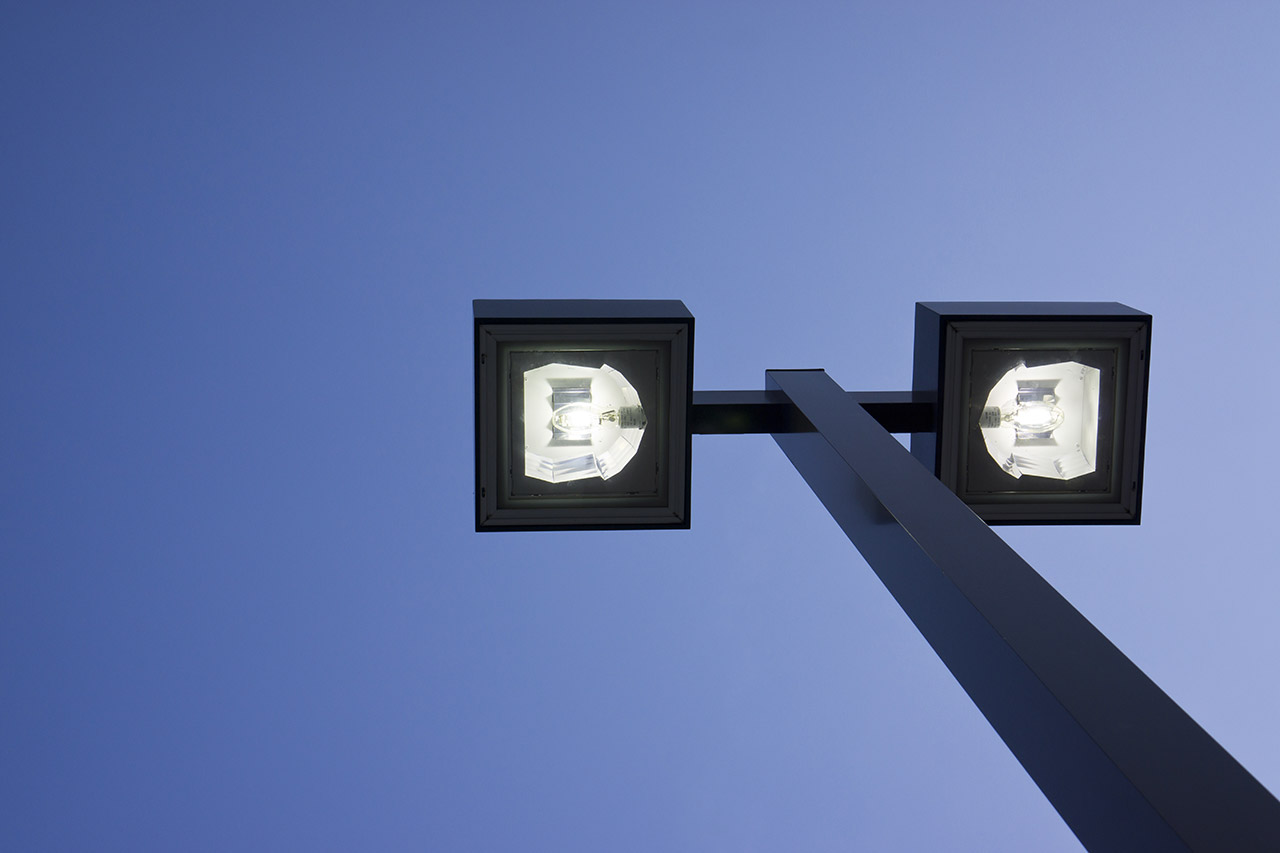 Streetlight against clear blue sky background.
